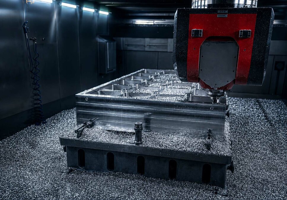 CNC milling machine precisely machining a large aluminum workpiece for toolmaking applications.