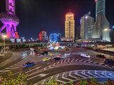 Nighttime street view in Shanghai’s financial district with illuminated skyscrapers, the Oriental Pearl Tower, and bustling traffic – from Jan Wengryn’s time in China.