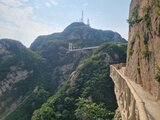 View of a suspension bridge in the Chinese mountains, surrounded by lush greenery and rocky cliffs – a snapshot from Jan Wengryn’s time abroad.