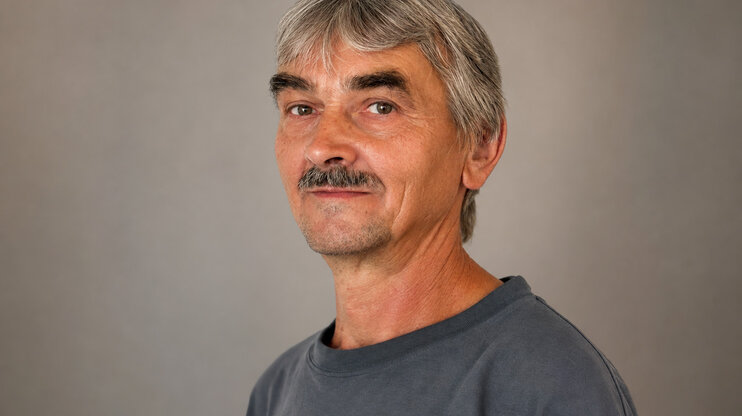 Profesionální portrét Františka Krumpolce před decentním šedým studiovým pozadím.
